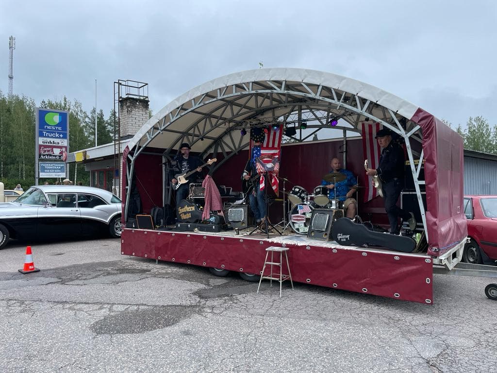 Bändi esiintyy katetulla mobiililavalla parkkipaikalla