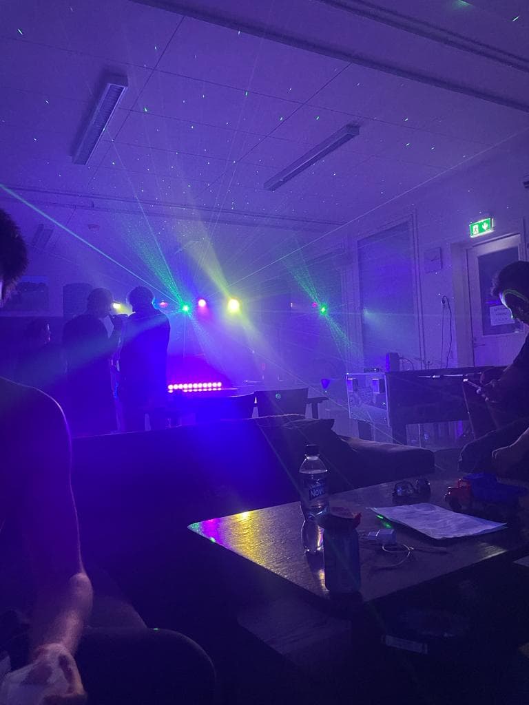 Laservalot ja violetti valaistus pimeässä juhlatilassa